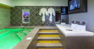 a bathroom with a swimming pool and a tub with a television at V Boutique Viaducto in Mexico City