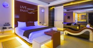 a bedroom with a large bed with a sign that reads live objects energy hottest at V Boutique Viaducto in Mexico City +3 photos