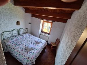 a small bedroom with a bed and a window at Isola Apartment with terrace and Stunning sea view in Corniglia