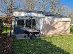 a small shed with a table and an umbrella at Puur 38 in Simpelveld
