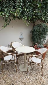 two chairs and a table and two tables and chairs at Boutique Hôtel Le Clos Huguerie - Bordeaux Centre in Bordeaux