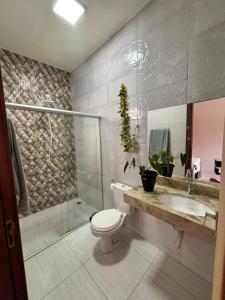 a bathroom with a toilet and a shower and a sink at Apartamento tecnoshow in Rio Verde