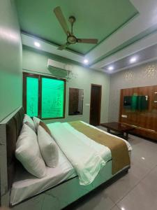 a bedroom with a large bed with a ceiling fan at The City View- Hotel and Restaurant in Bhiwāni