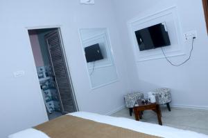 a bedroom with a bed and a chair and a tv at The City View- Hotel and Restaurant in Bhiwāni