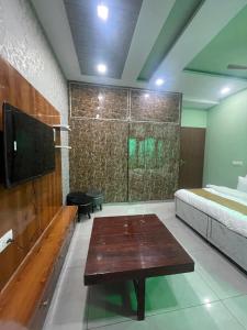 a room with a bed and a table and a tv at The City View- Hotel and Restaurant in Bhiwāni