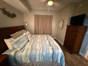 a bedroom with a bed with a television and a dresser at Romantic Beachfront Sunsets in Panama City Beach +68 photos