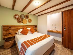 a bedroom with a large bed with orange pillows at Casa Sie in Villa de Leyva +185 photos