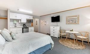a bedroom with a bed and a table and a kitchen at Ground Floor River Front Studio Cottage in Bend
