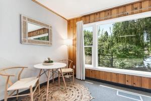 a dining room with a table and chairs and a window at Ground Floor River Front Studio Cottage in Bend +23 photos