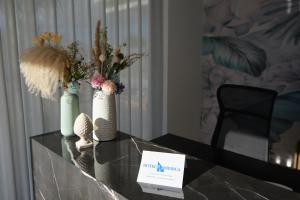 a table with vases and flowers on top of it at Le perle del golfo Scafati in Scafati