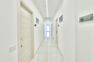 a hallway with white walls and white floors and a door at Le perle del golfo Scafati in Scafati