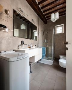 ein Badezimmer mit zwei Waschbecken, Toilette und Dusche in der Unterkunft Spacious 2BR Apartment for Families Central & Quiet Pisa in Pisa