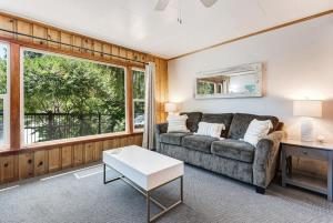 a living room with a couch and a table at Ground Floor Riverside Cottage with Patio in Bend
