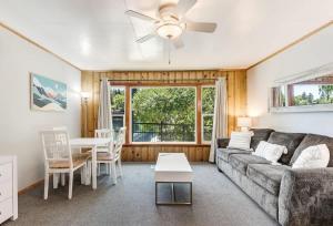 a living room with a couch and a table at Ground Floor Riverside Cottage with Patio in Bend