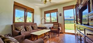 a living room with a couch and chairs and windows at Villa Trinamar - Casa rural en Valdes cerca de Luarca in Carcedo