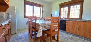 a kitchen with a table and chairs and a refrigerator at Villa Trinamar - Casa rural en Valdes cerca de Luarca in Carcedo