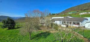 a house in a field with mountains in the background at Villa Trinamar - Casa rural en Valdes cerca de Luarca in Carcedo