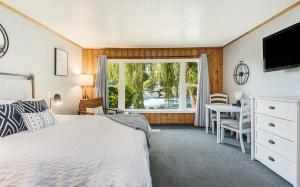 a bedroom with a bed and a window and a desk at Pet Friendly Riverside Studio in Downtown Bend in Bend