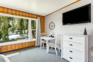 a bedroom with a desk and a tv and a window at Pet Friendly Riverside Studio in Downtown Bend in Bend +24 photos