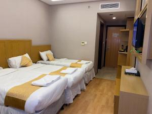a hotel room with two beds and a flat screen tv at فندق العزيزية توصيل للحرم in Mecca +48 photos