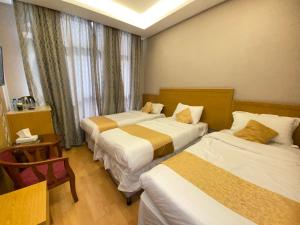 a hotel room with three beds and a window at فندق العزيزية توصيل للحرم in Mecca