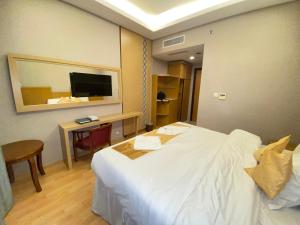 a hotel room with a large white bed and a desk at فندق العزيزية توصيل للحرم in Mecca