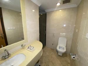 a bathroom with a sink and a toilet and a mirror at فندق العزيزية توصيل للحرم in Mecca