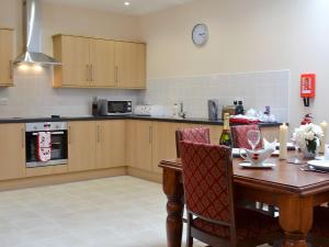 a kitchen with a wooden table with chairs and a dining room at The Parlour - Op4 in Carmarthen