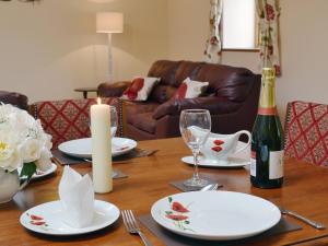 a wooden table with plates and a bottle of wine at The Parlour - Op4 in Carmarthen +7 photos