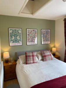 a bedroom with a bed and three pictures on the wall at Rosehill annexe in Knighton
