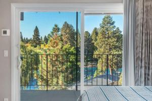 a bedroom with a large window with a view at Updated Condo with Deschutes River View in Bend