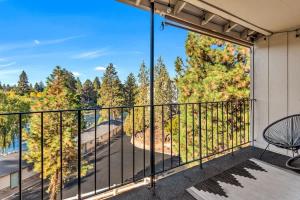 a balcony with a view of the water and trees at Updated Condo with Deschutes River View in Bend