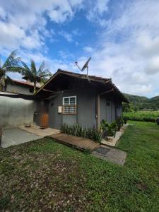 a house with a lawn in front of it at Chalés Cambury in Camburi