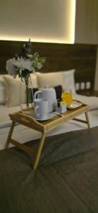a coffee table with cups and a vase with flowers at HB Selection Hotel in Miraflores