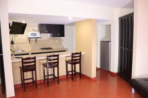 a kitchen with a counter and stools in a room at Hacienda Blue Bay in Mazatlán