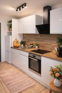 a kitchen with white cabinets and a sink at La Petite Escale Manosquine in Manosque +2 photos