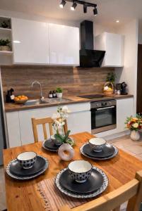 a kitchen with a wooden table with four dishes on it at La Petite Escale Manosquine in Manosque