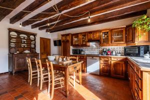 a kitchen with wooden cabinets and a table and chairs at La Maison de Barbara in La Guiche