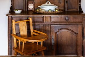 a wooden cabinet with a chair and a bowl on it at La Maison de Barbara in La Guiche +26 photos