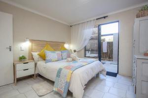 a bedroom with a bed and a large window at Edjami River View in Marloth Park