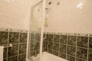 a bathroom with a shower and a bath tub at Rossgier Inn in Lifford
