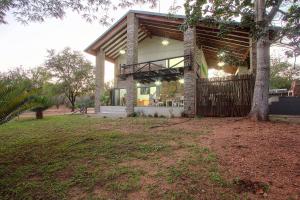 a house with a tree in front of it at Edjami River View in Marloth Park