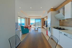 a kitchen and living room with a table and chairs at Villa Sheyma in Kalkan