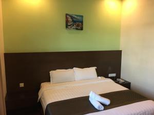 Una cama o camas en una habitación de Lintas Plaza Hotel