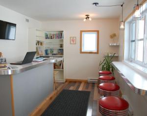 ein Zimmer mit einer Bar mit Hockern und einem Laptop in der Unterkunft Le Perchoir in Saint-Félix-d'Otis