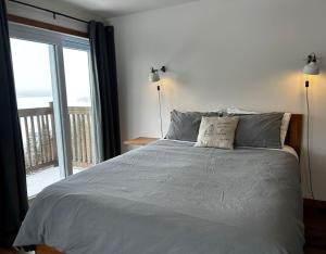 ein Schlafzimmer mit einem Bett und Meerblick in der Unterkunft Le Perchoir in Saint-Félix-d'Otis
