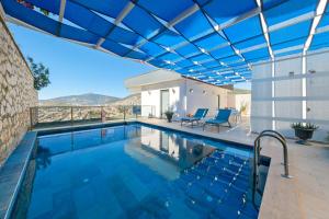 a large swimming pool with a blue roof at Villa Sheyma in Kalkan