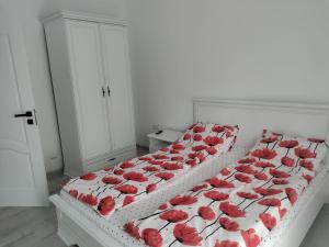a bed with red roses on it in a room at Park & Rest Apartment in Mărtineşti