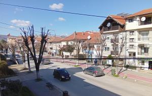 two cars parked on a city street with buildings at Harmony Apartment in Strumica
