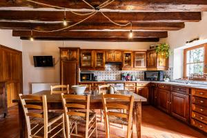 a kitchen with a wooden table and chairs in a kitchen at La Maison de Barbara in La Guiche